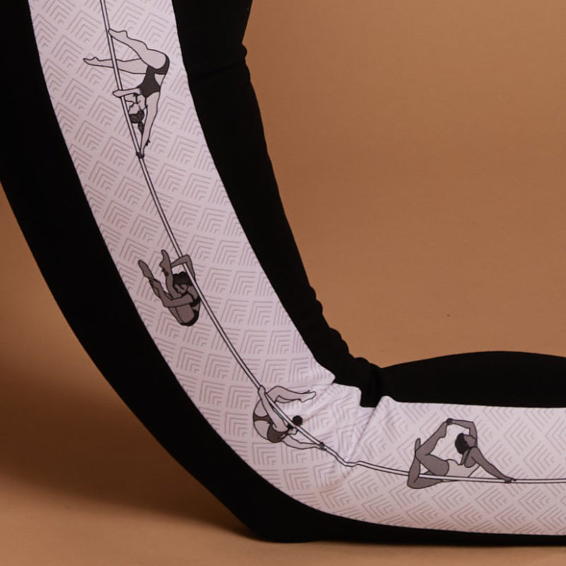 close-up of the print of the Signature Pole leggings, focus is on four female figures performing various pole dance tricks including back bends, forward folds, and elbow ayesha - focus on flexibility
